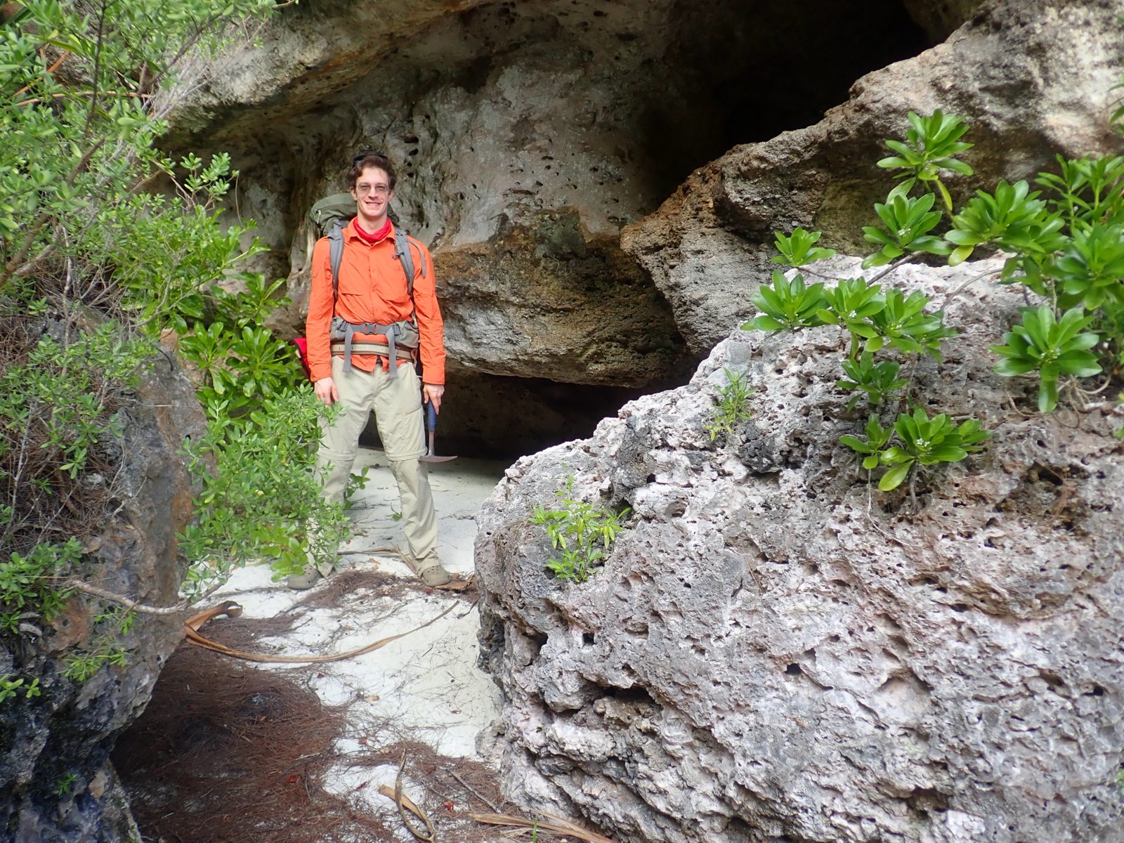 Araoa sand and grainstone level: Roger stands on loose sand/grainstone below a higher grainstone surface, prompting a question about how little elevation change would alter the interpretation.